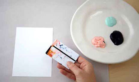 Dip the credit card into sand-color paint on one side of the edge of the credit card.